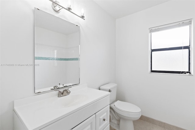 bathroom featuring baseboards, vanity, and toilet