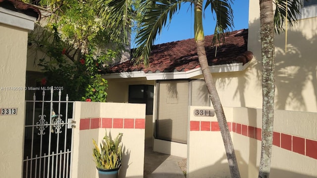 exterior space with a gate and stucco siding