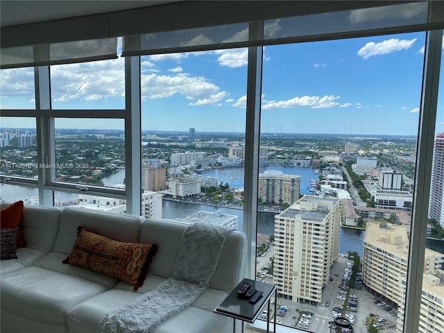 sunroom / solarium featuring a water view and a city view