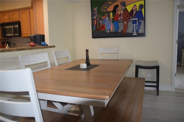 dining space featuring baseboards and wood finished floors