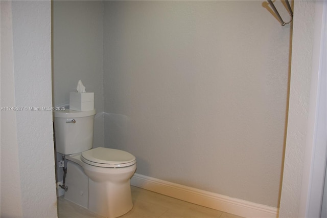 bathroom featuring baseboards and toilet