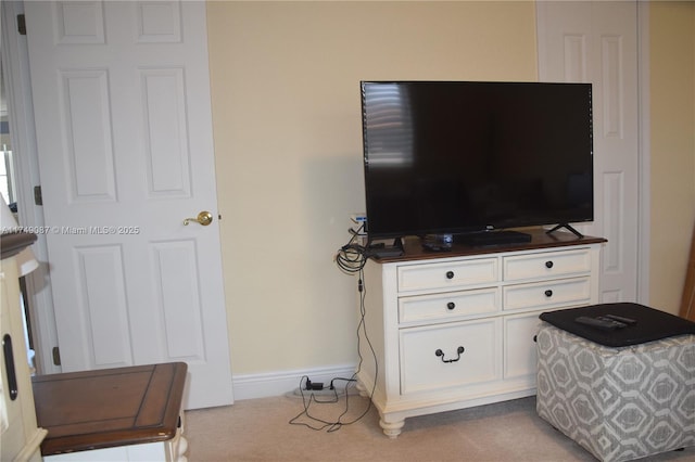 bedroom with light colored carpet and baseboards