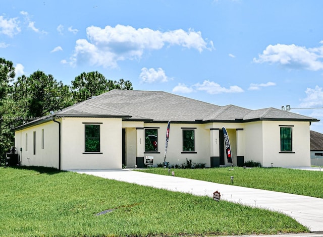 prairie-style house featuring roof with shingles, a front lawn, and stucco siding