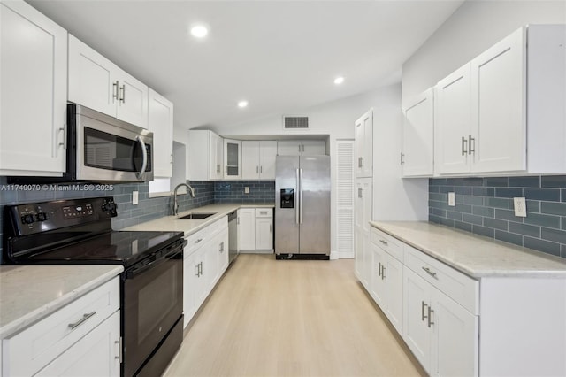 3883 Chickasha Rd, Lake Worth, FL 33462 - kitchen featuring stainless steel appliances, backsplash, light wood-style flooring, white cabinetry, and light stone countertops