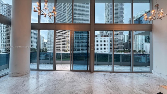 doorway to outside with a view of city, marble finish floor, a chandelier, and a wealth of natural light