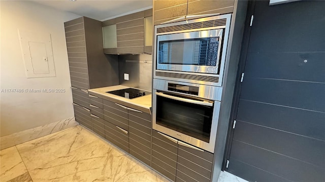 kitchen with electric panel, appliances with stainless steel finishes, marble finish floor, light countertops, and wall chimney range hood