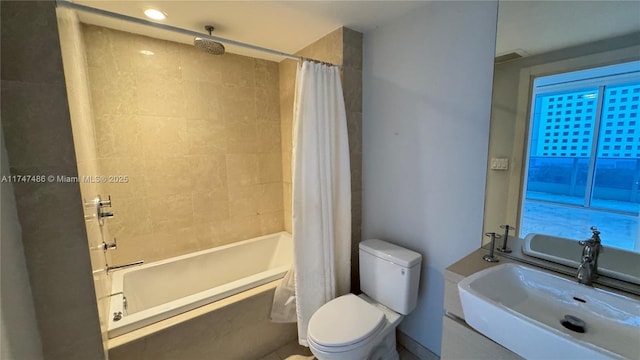 bathroom featuring tiled shower / bath combo, a sink, and toilet