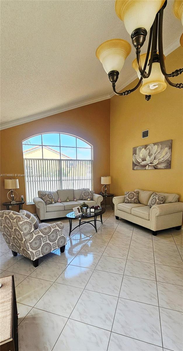 18860 NW 12th St, Pembroke Pines, FL 33029 - living area with crown molding, a textured ceiling, and vaulted ceiling