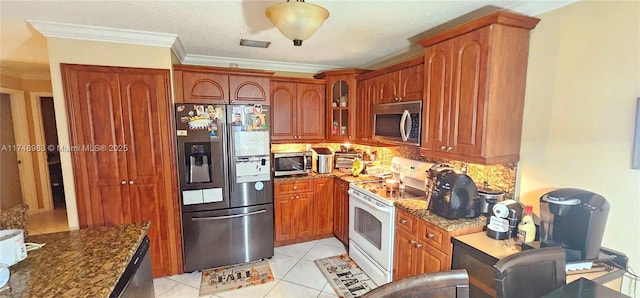 kitchen featuring glass insert cabinets, light tile patterned floors, appliances with stainless steel finishes, and dark stone counters