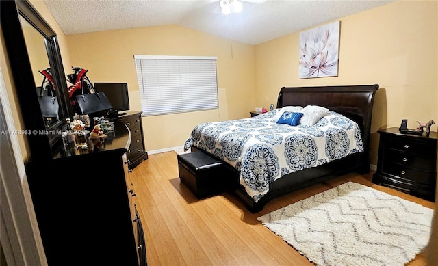 bedroom featuring lofted ceiling, baseboards, and light wood finished floors