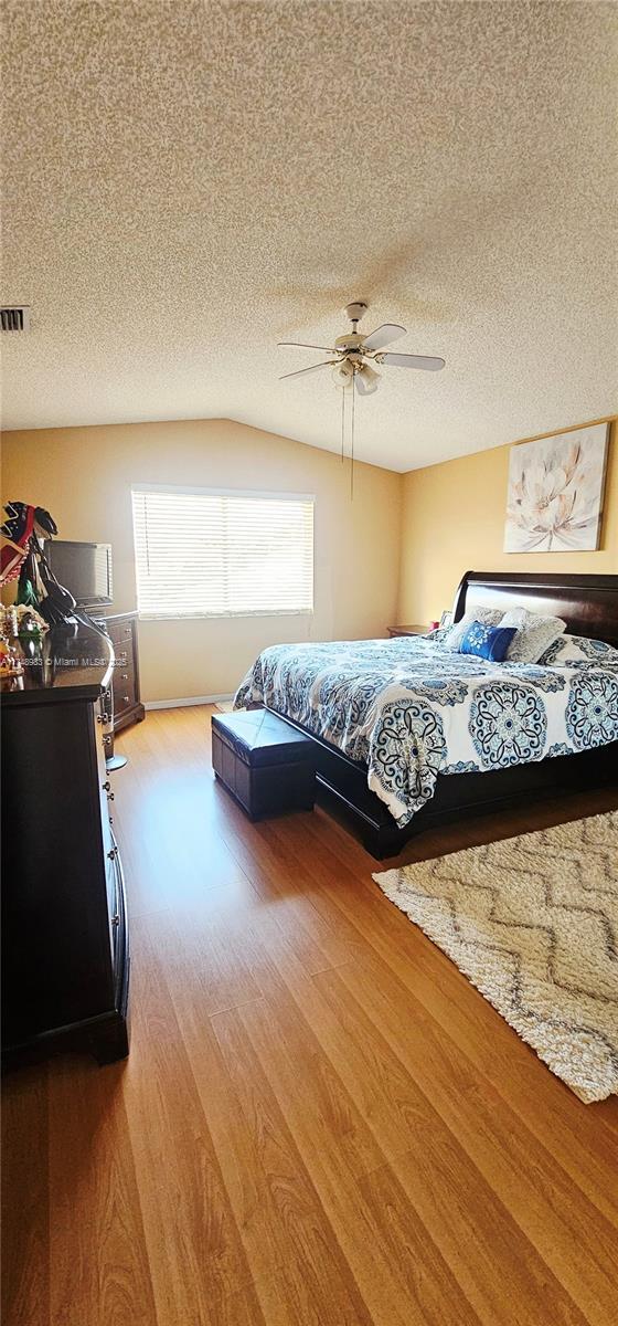 18860 NW 12th St, Pembroke Pines, FL 33029 - bedroom with wood finished floors, ceiling fan, and a textured ceiling