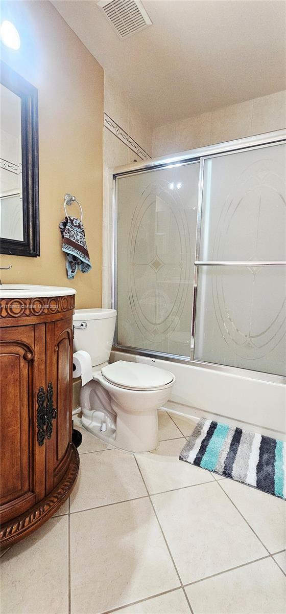 18860 NW 12th St, Pembroke Pines, FL 33029 - full bathroom with toilet, combined bath / shower with glass door, vanity, and tile patterned floors