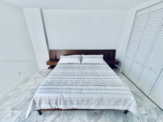 bedroom featuring marble finish floor and baseboards