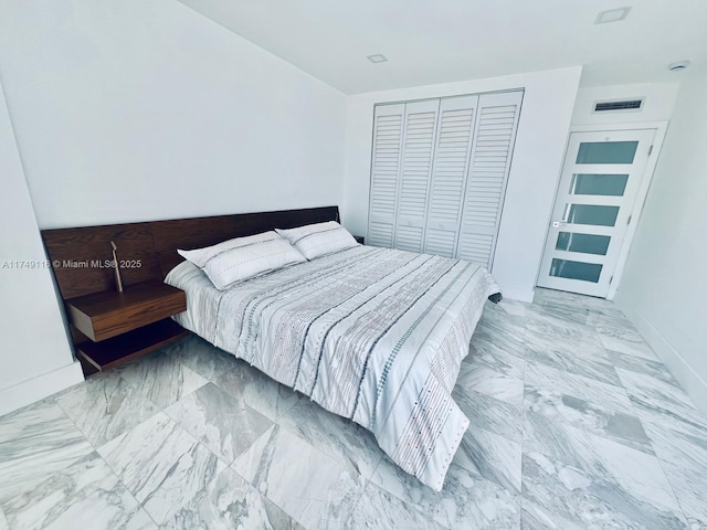 bedroom featuring marble finish floor, a closet, visible vents, and baseboards