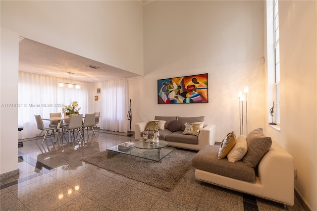 living room with granite finish floor, a high ceiling, and baseboards