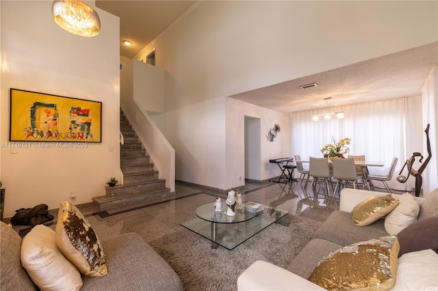 living room featuring visible vents, granite finish floor, stairway, a high ceiling, and baseboards