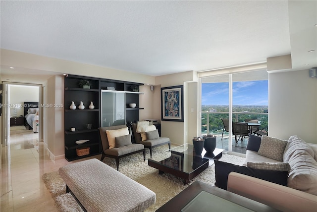 living room featuring a textured ceiling, light tile patterned flooring, baseboards, and floor to ceiling windows