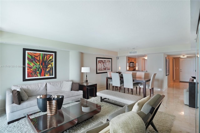 living area featuring marble finish floor and baseboards