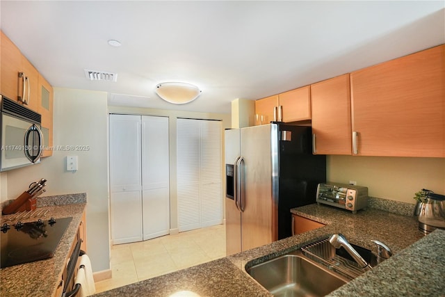 kitchen featuring light tile patterned floors, a toaster, visible vents, appliances with stainless steel finishes, and a sink