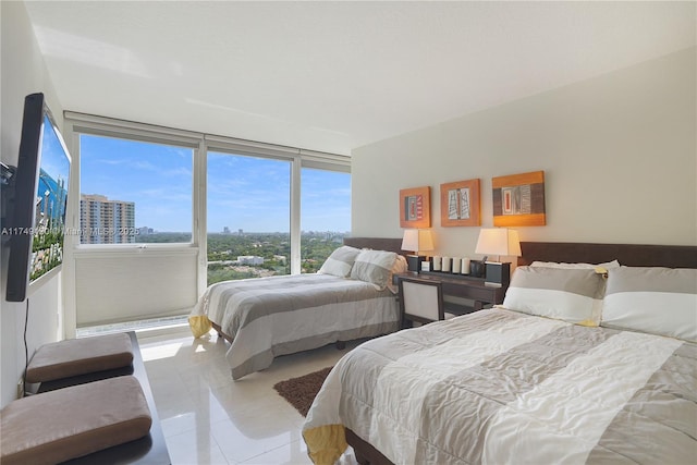 bedroom featuring light tile patterned flooring and floor to ceiling windows