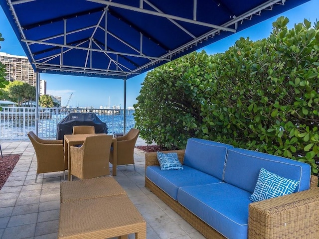 view of patio / terrace featuring an outdoor hangout area, outdoor dining area, and a water view