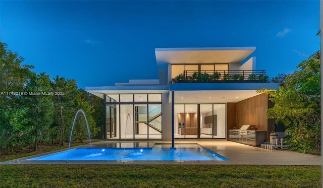 rear view of house featuring a balcony, an outdoor pool, a patio, and area for grilling