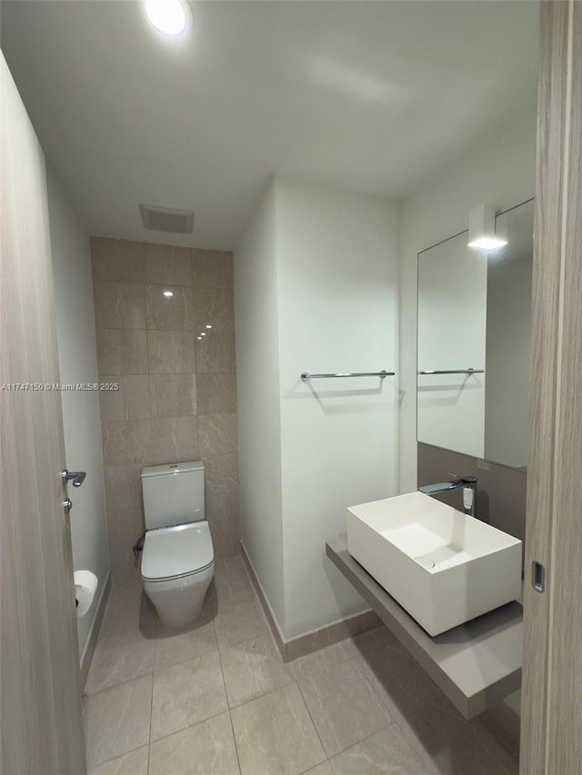1000 Brickell Plz Unit 4314, Miami, FL 33131 - half bath featuring tile patterned flooring, a sink, toilet, and tile walls