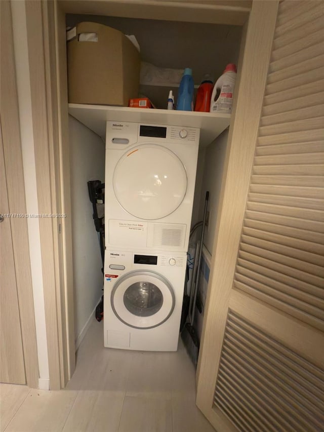 1000 Brickell Plz Unit 4314, Miami, FL 33131 - clothes washing area featuring laundry area, stacked washing maching and dryer, and light tile patterned flooring