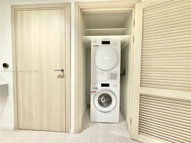 1000 Brickell Plz Unit 4314, Miami, FL 33131 - laundry room featuring stacked washing machine and dryer and tile patterned floors