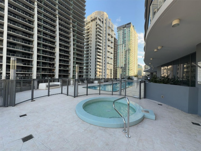 1000 Brickell Plz Unit 4314, Miami, FL 33131 - view of swimming pool featuring a city view, fence, a hot tub, and a patio
