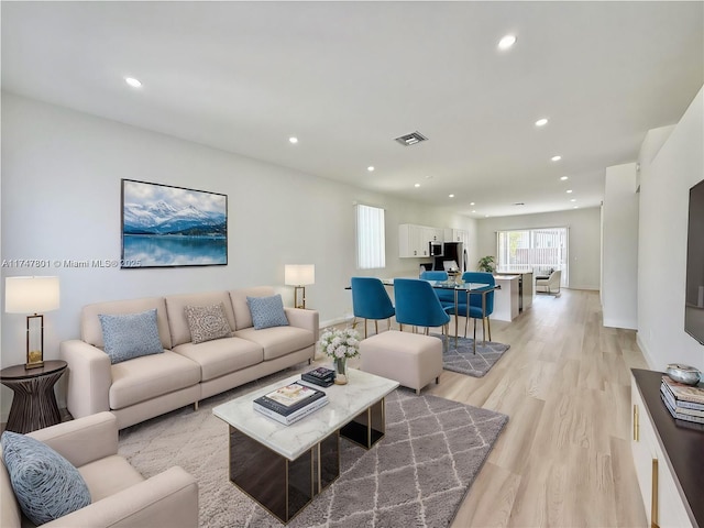 living room featuring recessed lighting, light wood-style flooring, baseboards, and visible vents