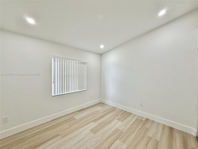 empty room with light wood-style flooring, baseboards, and recessed lighting