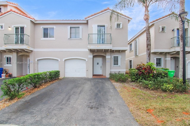 view of property featuring a garage, driveway, and stucco siding