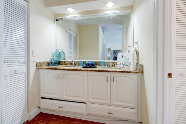 full bathroom with recessed lighting, a closet, a sink, and double vanity