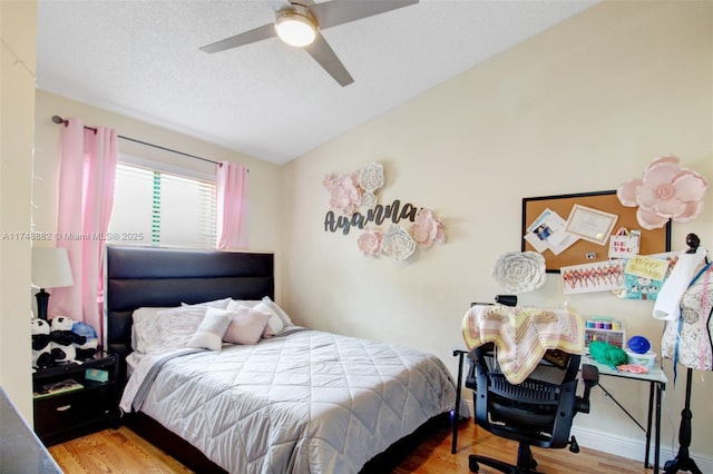 bedroom with lofted ceiling, ceiling fan, a textured ceiling, and wood finished floors