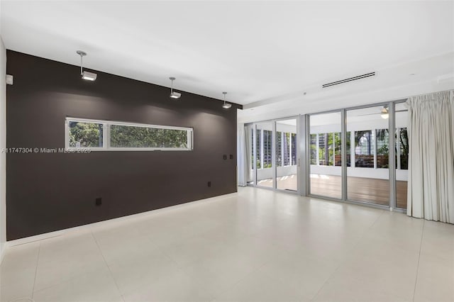 unfurnished room with an accent wall and visible vents