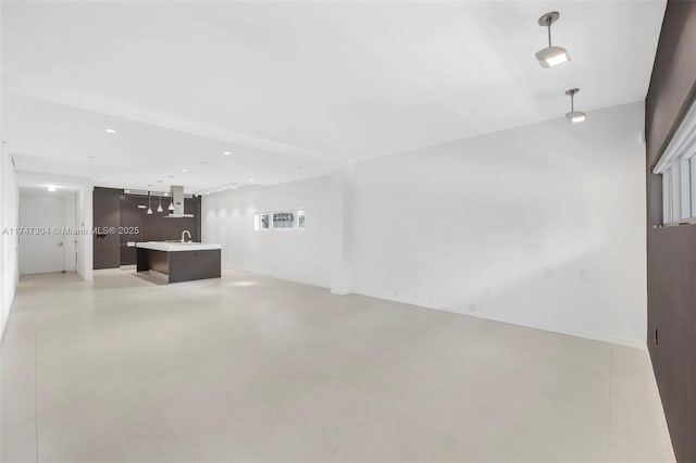 unfurnished living room with a sink and recessed lighting