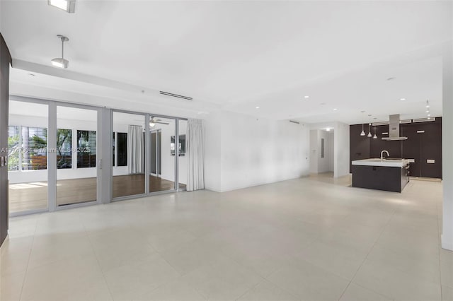 unfurnished living room with a sink and recessed lighting