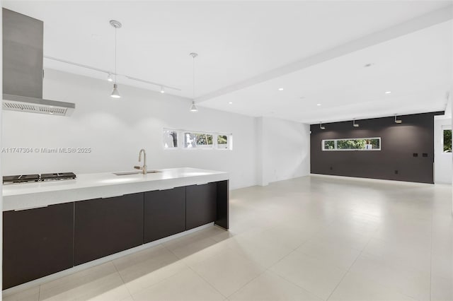 kitchen with a sink, light countertops, ventilation hood, modern cabinets, and pendant lighting