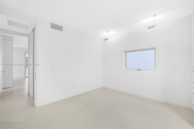 unfurnished room with visible vents and baseboards