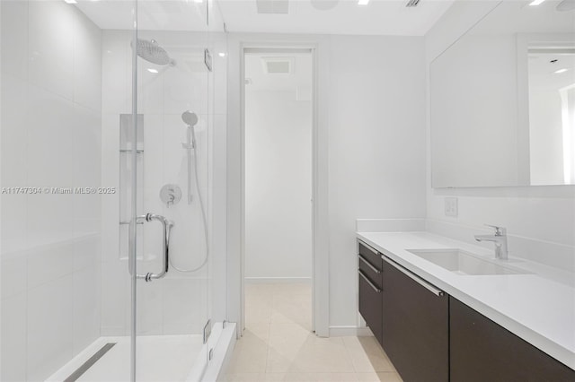 bathroom featuring tile patterned flooring, a shower stall, vanity, and baseboards