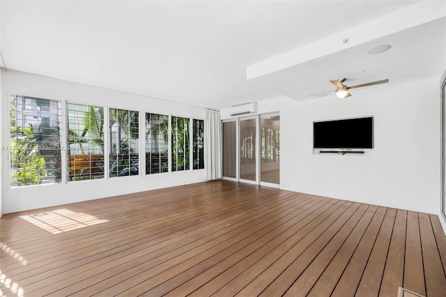 unfurnished sunroom featuring a ceiling fan and a wall mounted AC