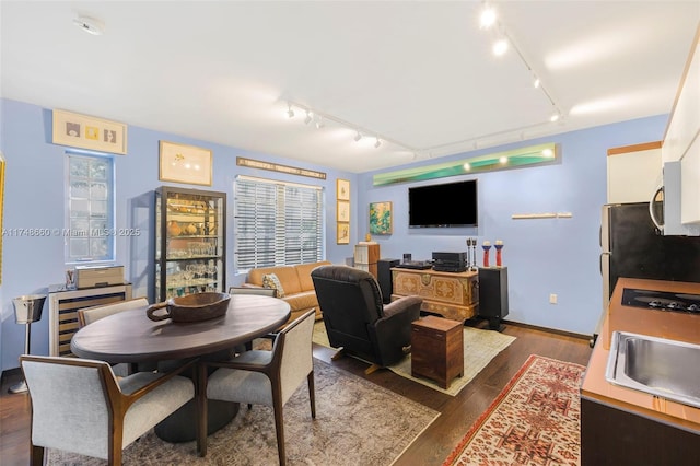 dining space featuring dark wood-style floors and baseboards