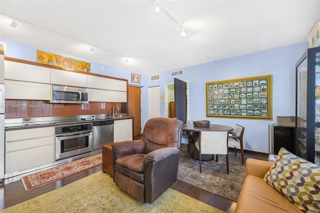 kitchen featuring white cabinets, dark wood-style floors, stainless steel countertops, and stainless steel appliances