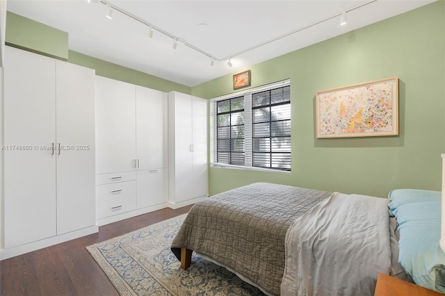 bedroom with dark wood-type flooring and rail lighting