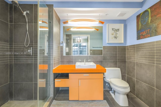 full bath featuring a stall shower, visible vents, toilet, vanity, and tile walls