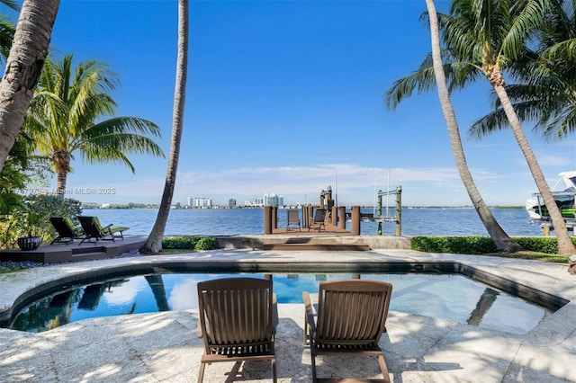 view of swimming pool with a dock, a water view, and boat lift