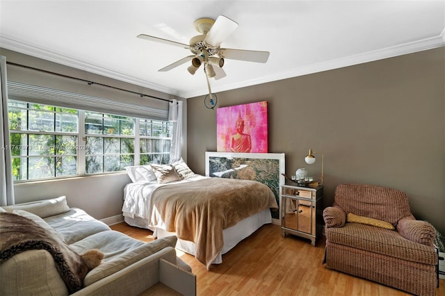 bedroom featuring ornamental molding, a ceiling fan, and light wood-style floors