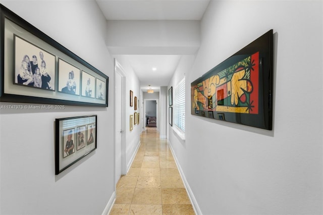 corridor with stone finish floor and baseboards