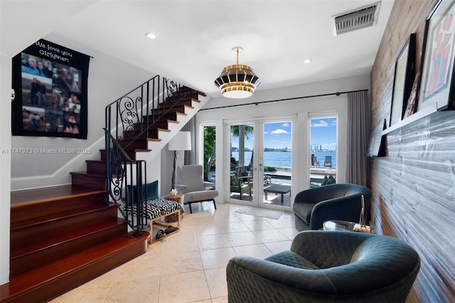 foyer with stairs, recessed lighting, a water view, visible vents, and tile patterned floors